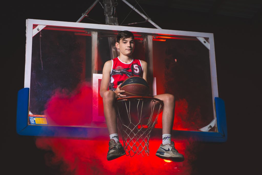 Portrait créatif d'un joueur de basket assis sur le panier Séance photo sportive réalisée près de Montceau-les-Mines